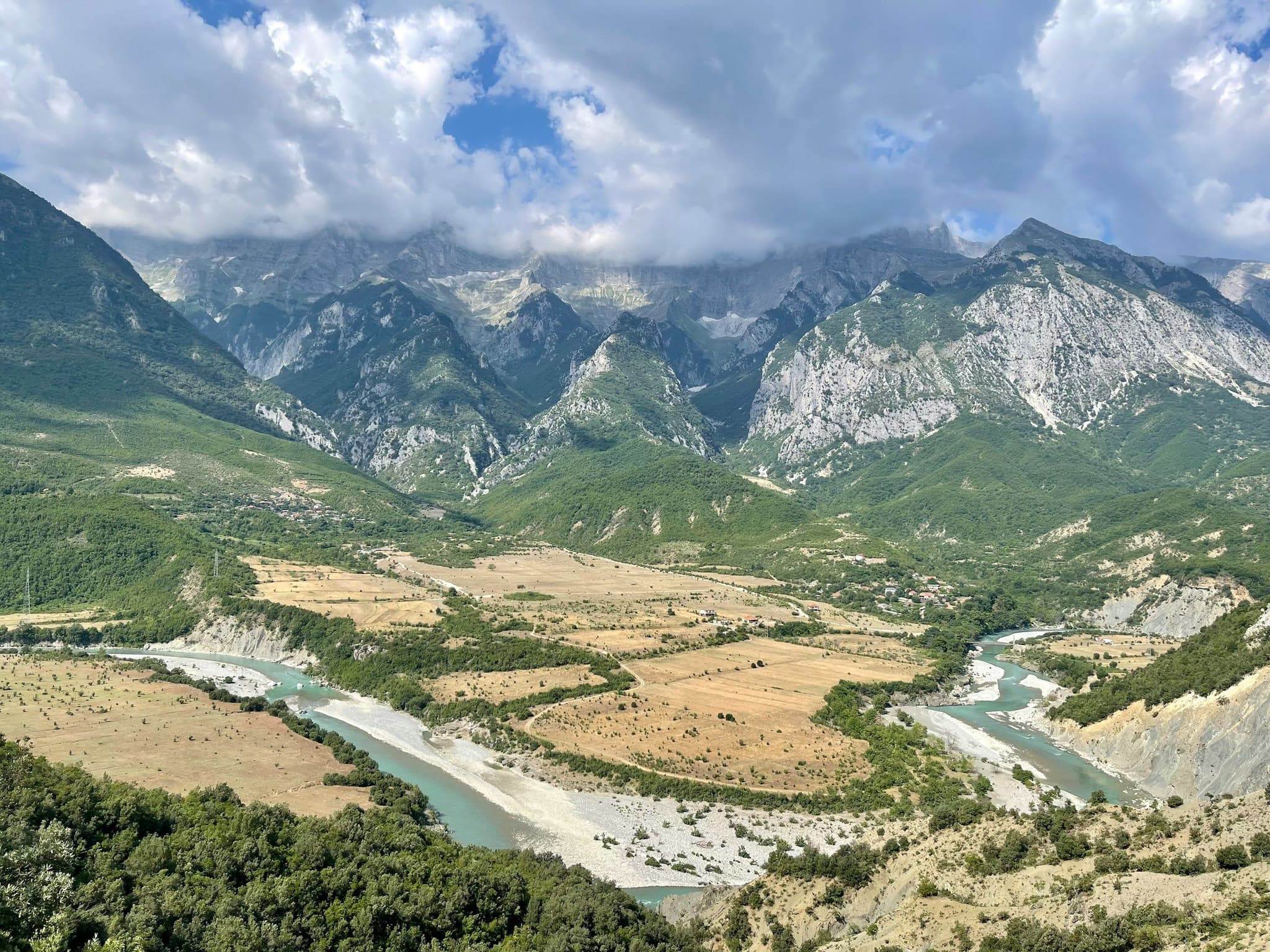 The Vjosa river winding through a valley below high mountains