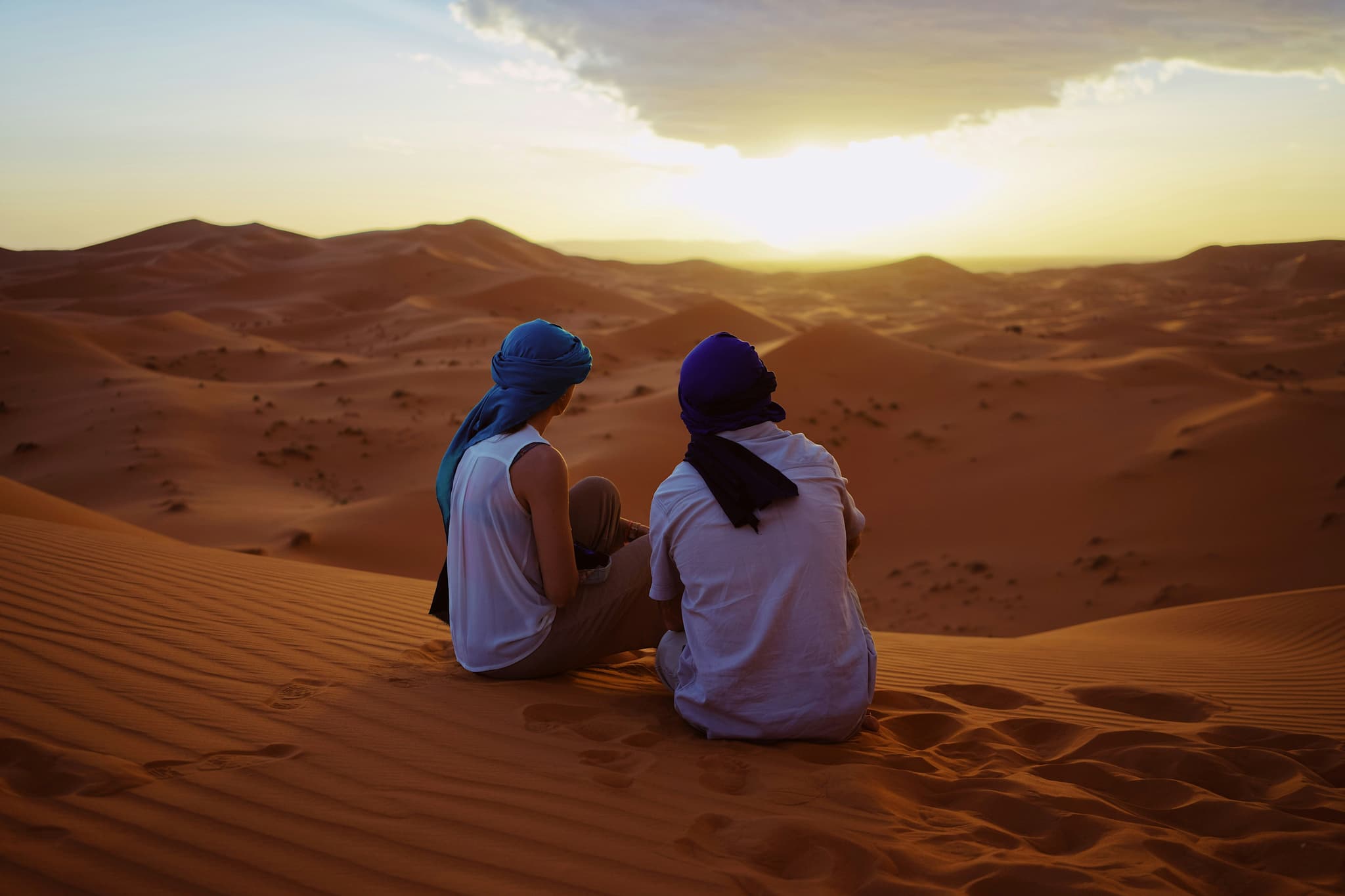 Two people in the desert during sunrise