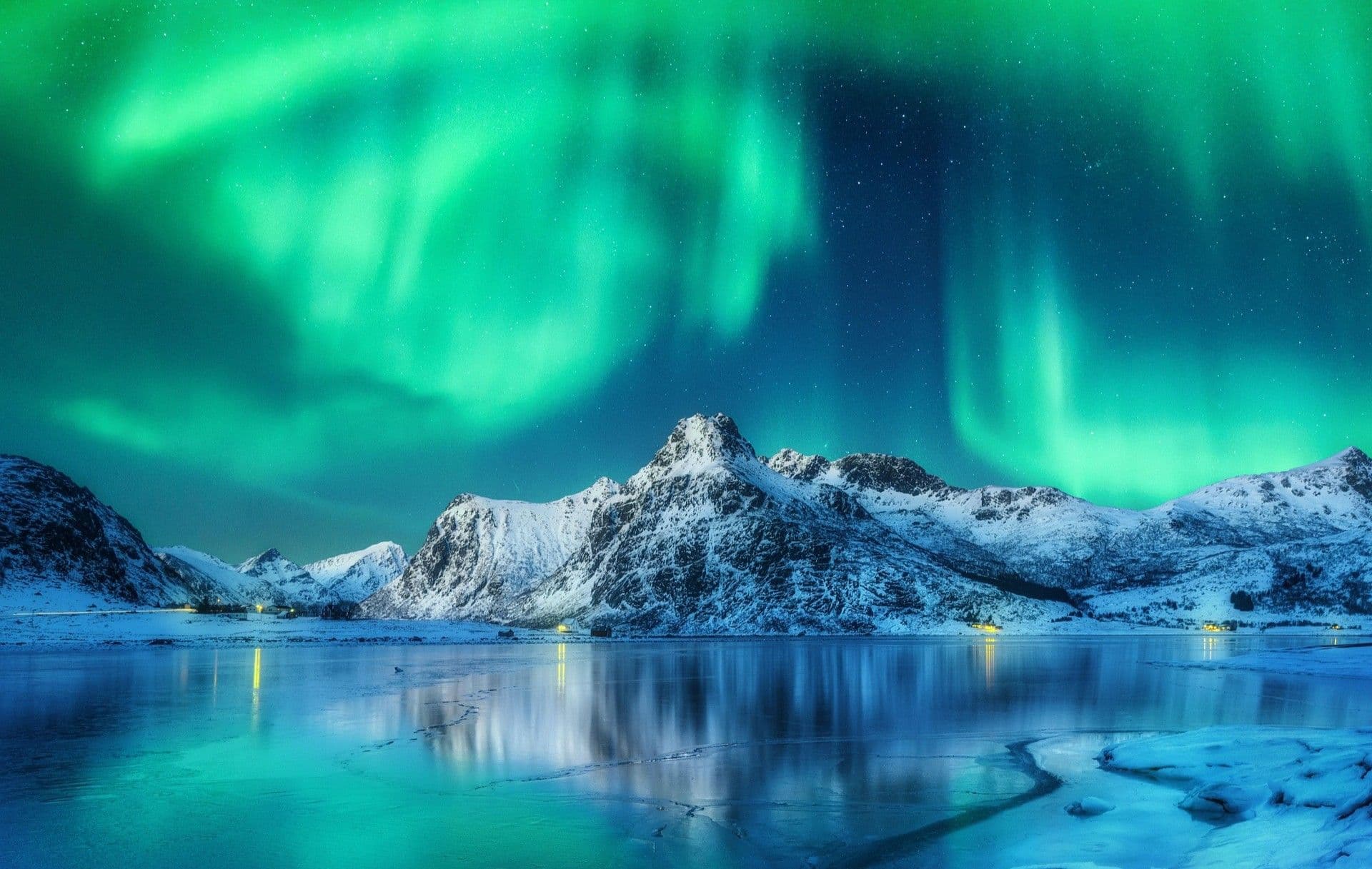 Green aurora borealis lighting up the night sky above a frozen landscape in Iceland