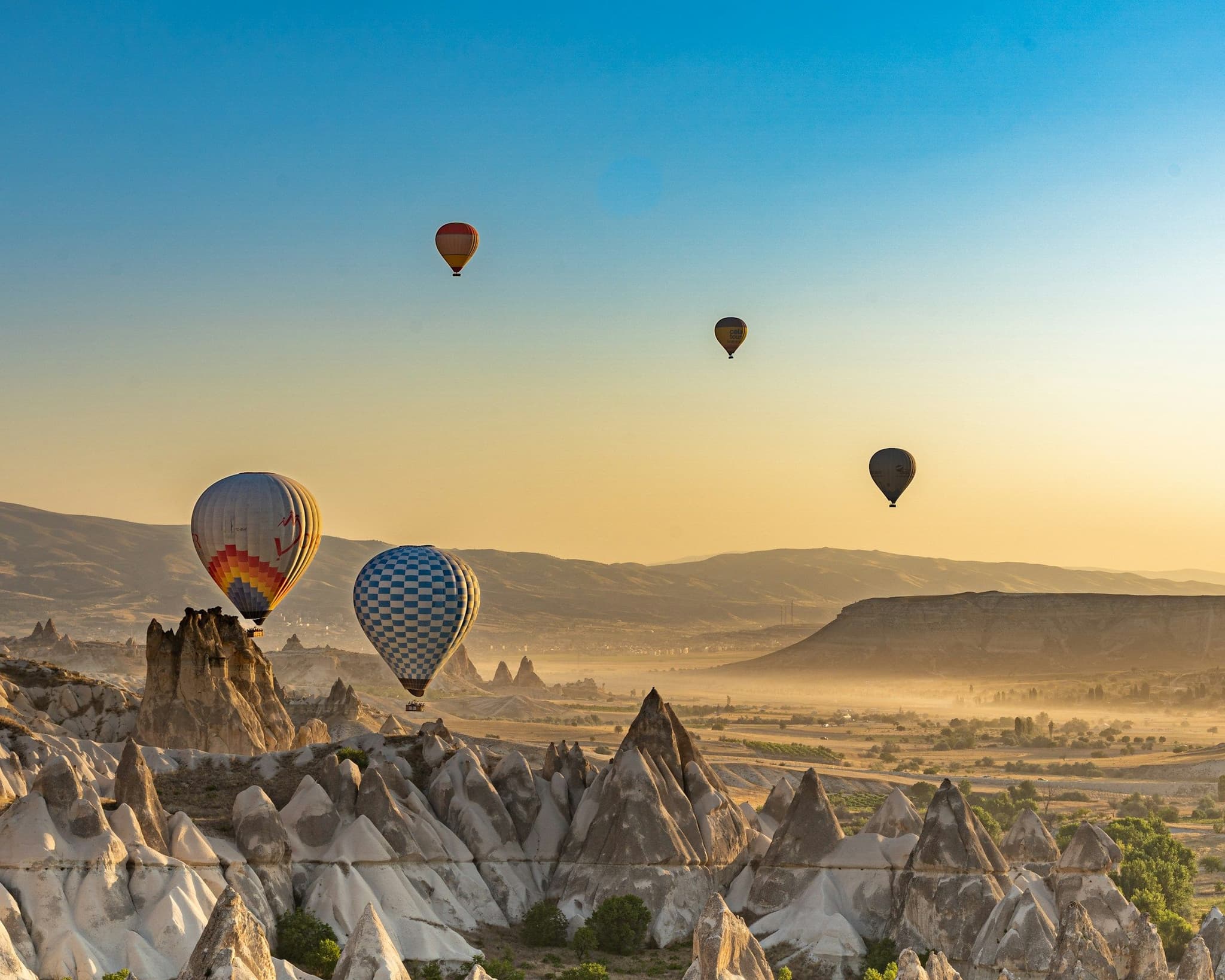 Hot air balloons flying over a valley in Cappadocia