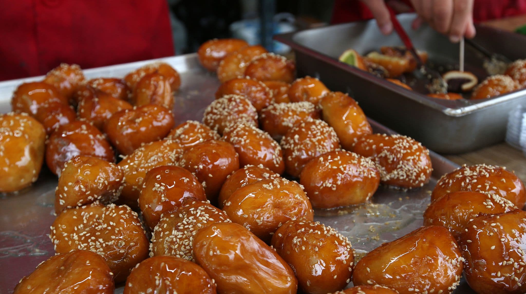 Liqimat dumplings with seseme, they are crispy and golden on the outside, and soft and fluffy on the inside.