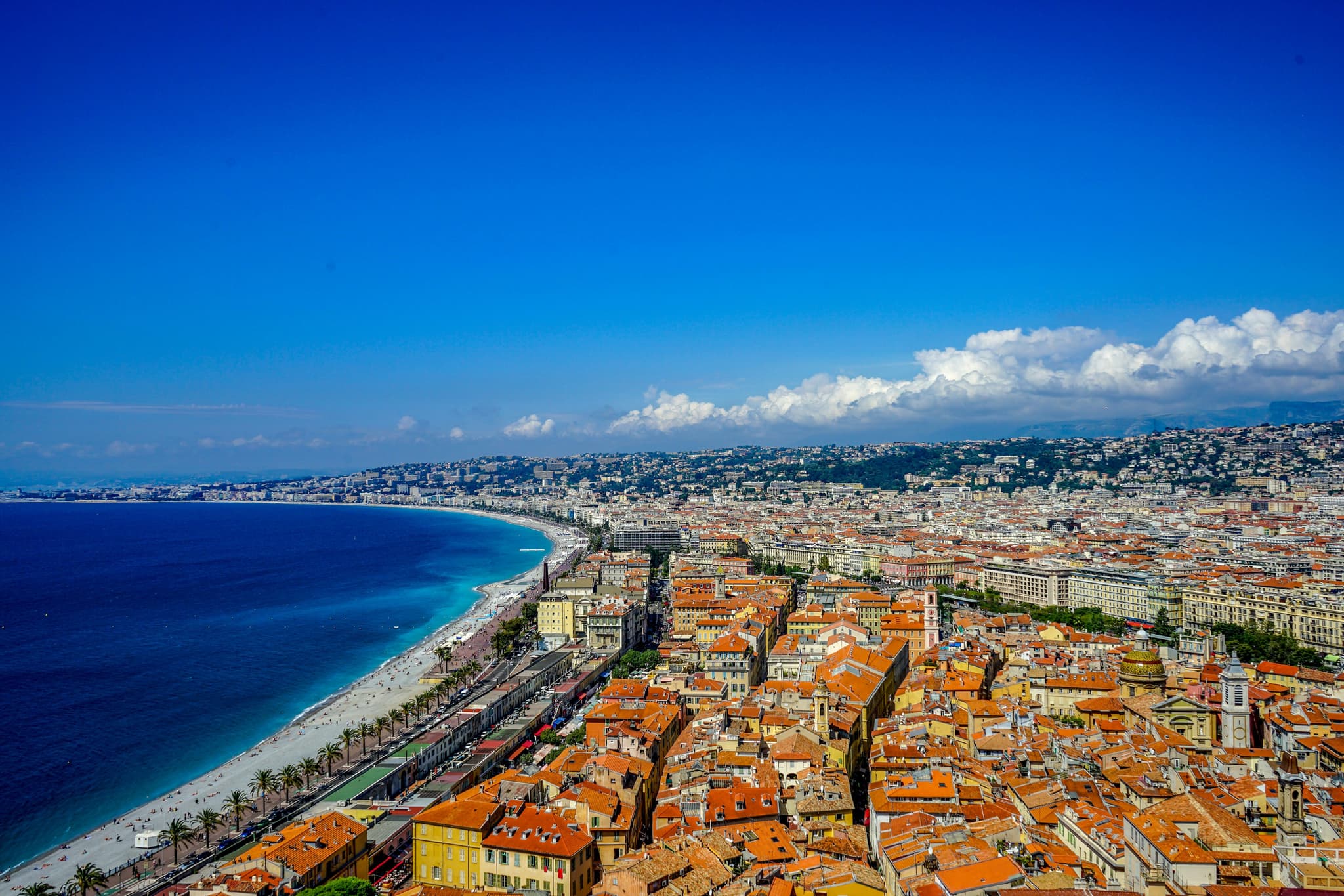 Beach and city with orange roofs from above in Nice on the French Riviera