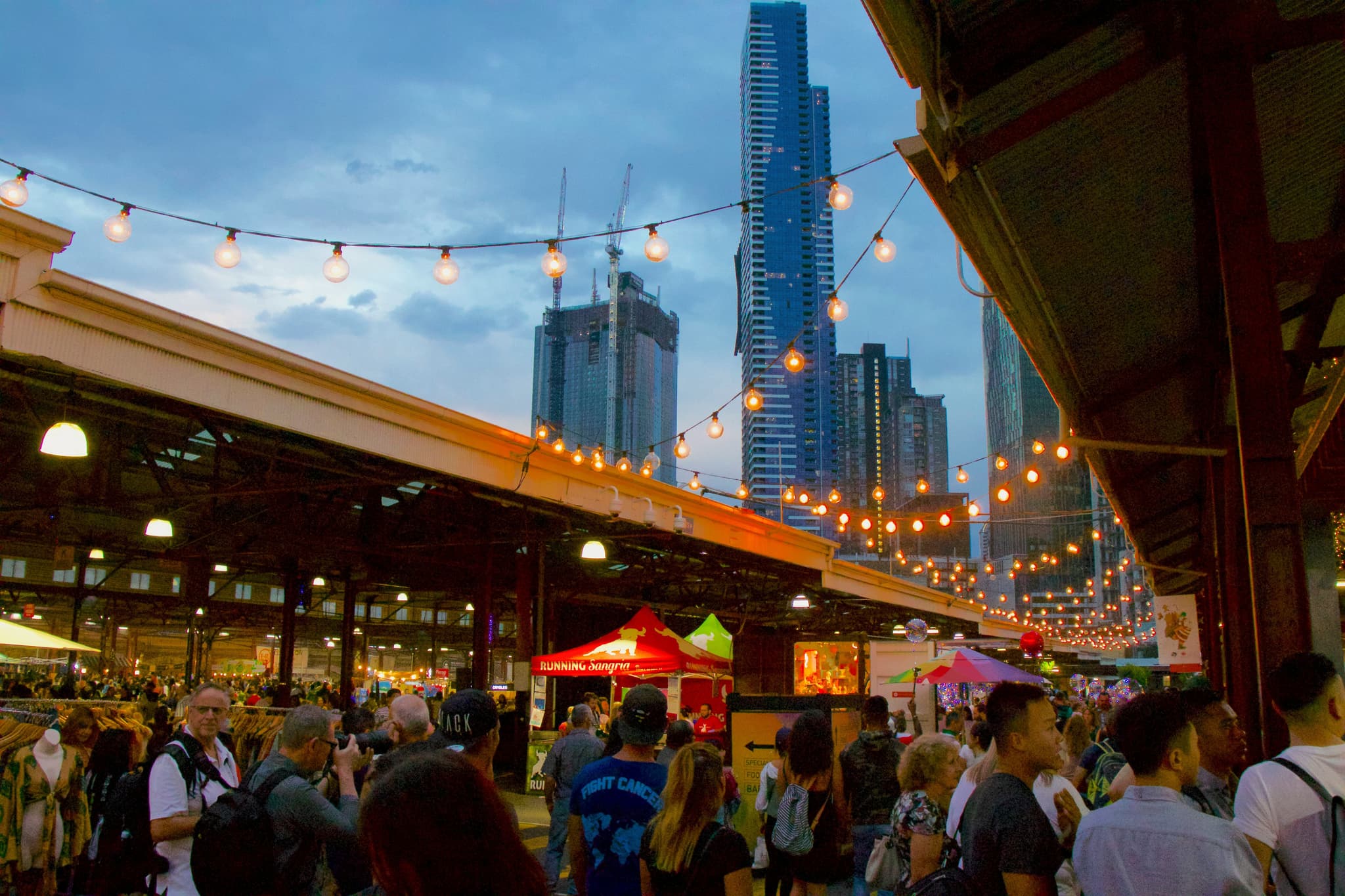 Street food in Melbourne's Victoria market filled with people and decorative lights