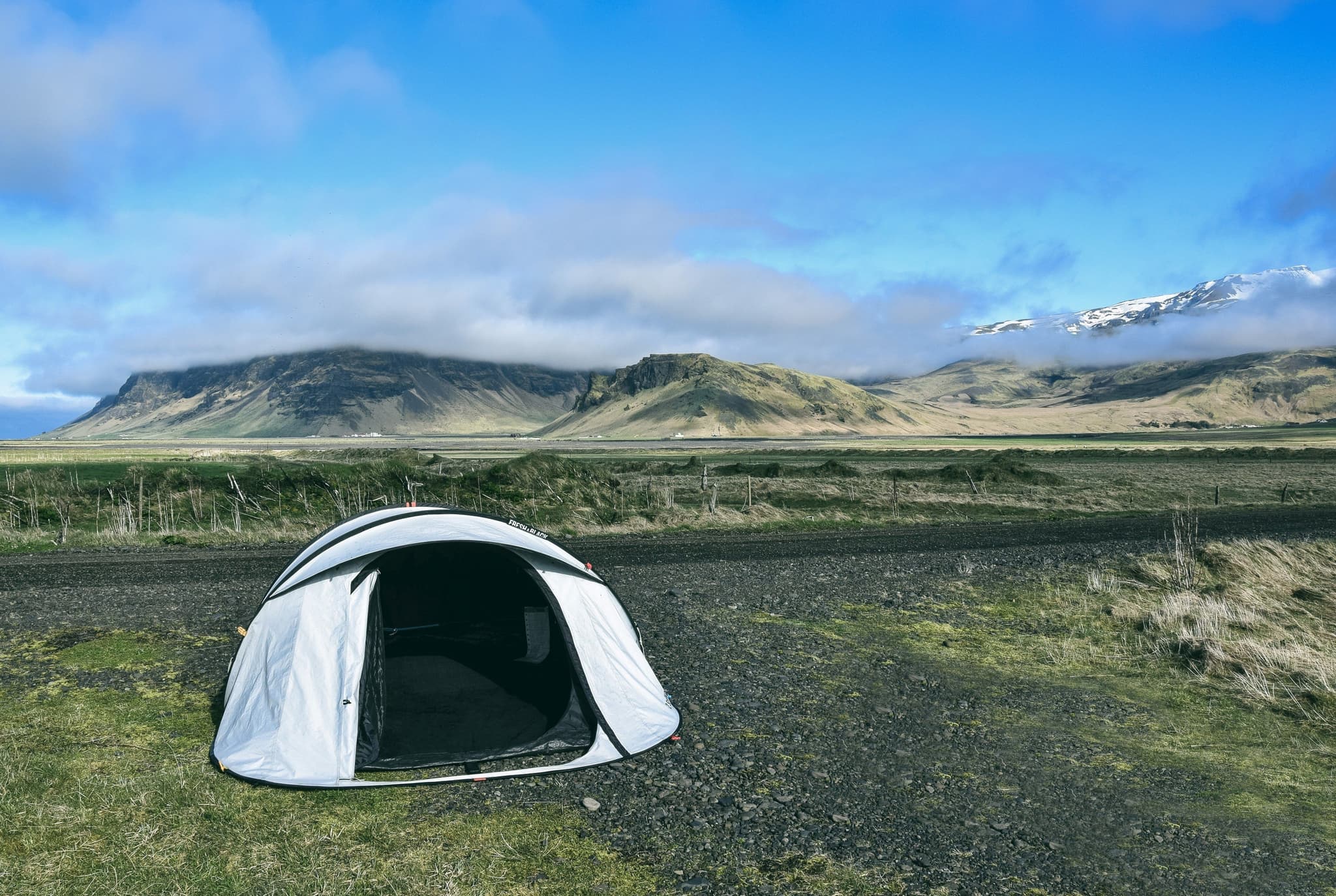 Camping in Iceland in summer, a tent on a green field of grass
