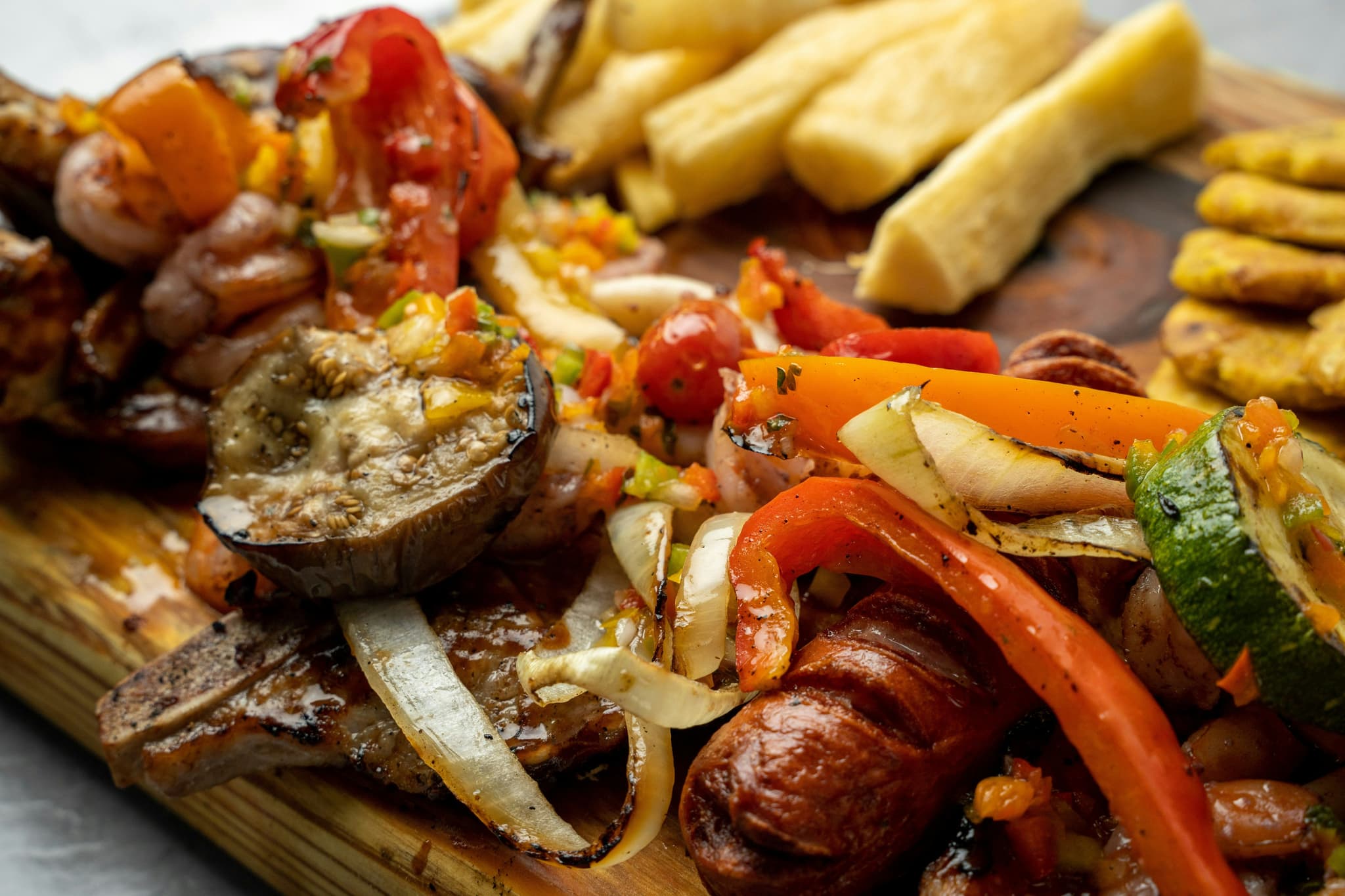 Plate of bandeja paisa with sausage, fries, and vegetables