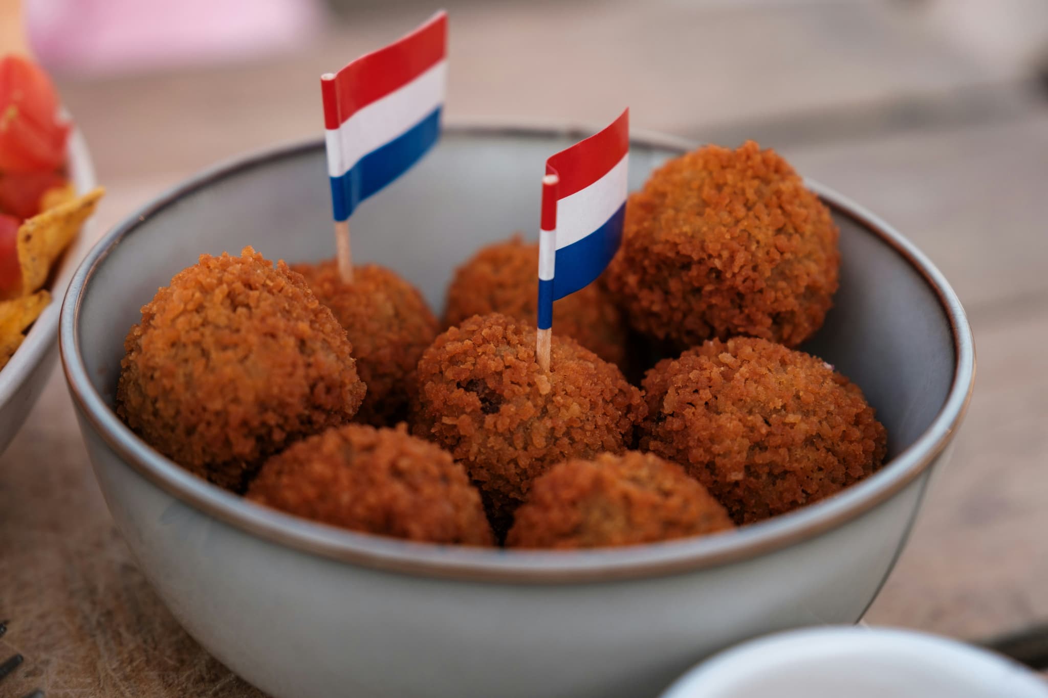 Fried bitterballen in a bowl with tiny dutch flags