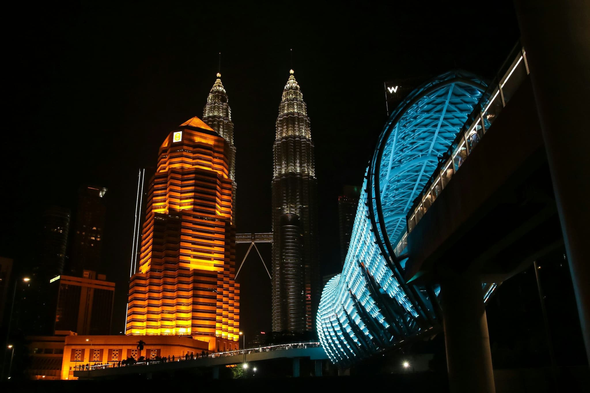 The Saloma Link bridge lit up at night with the Petronas Towers behind, Kuala Lumpur