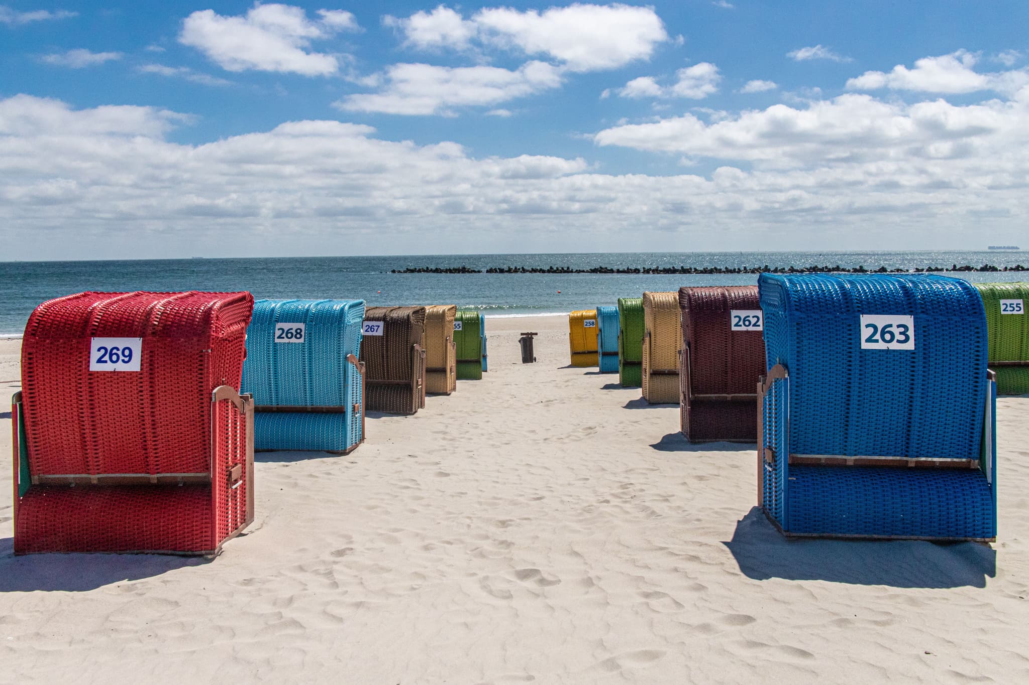 A bright sunny photo of classic wicker baskets on a sandy shore