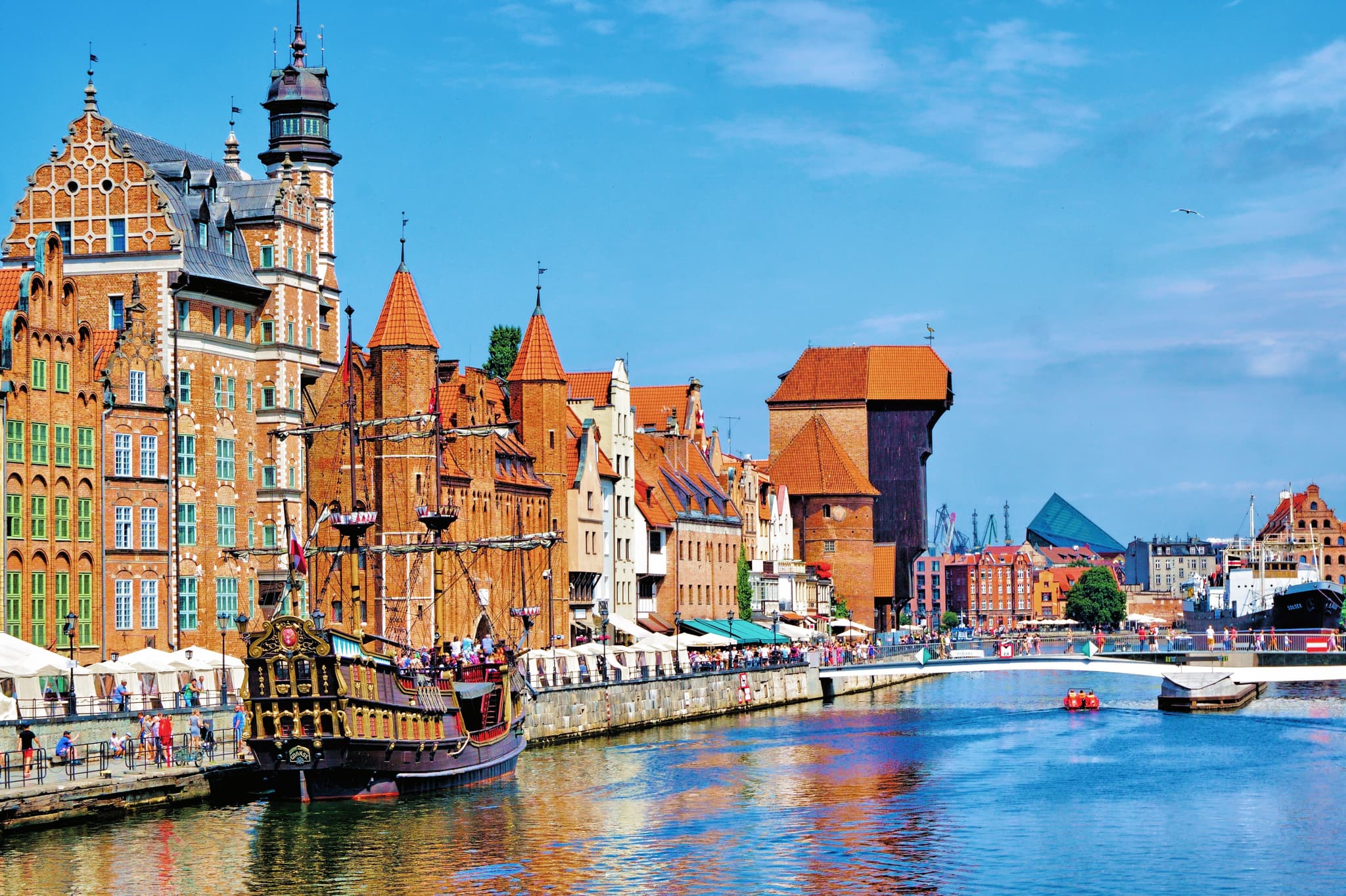 Riverside houses in Gdansk on a clear blue sky and a pirate ship
