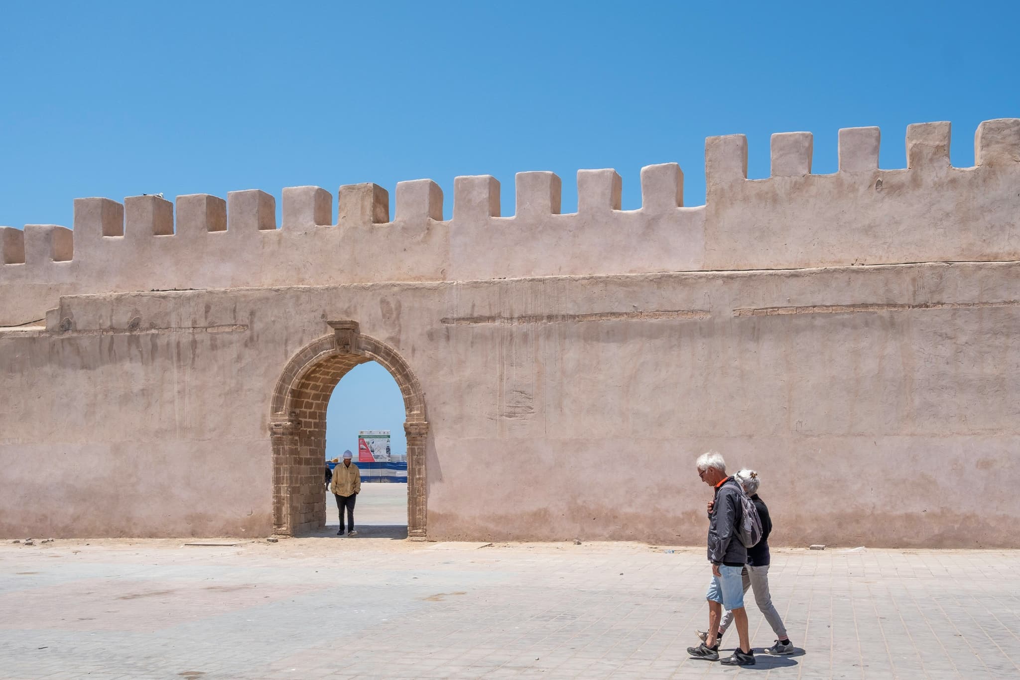 Two tourists walking near a wall in morocco