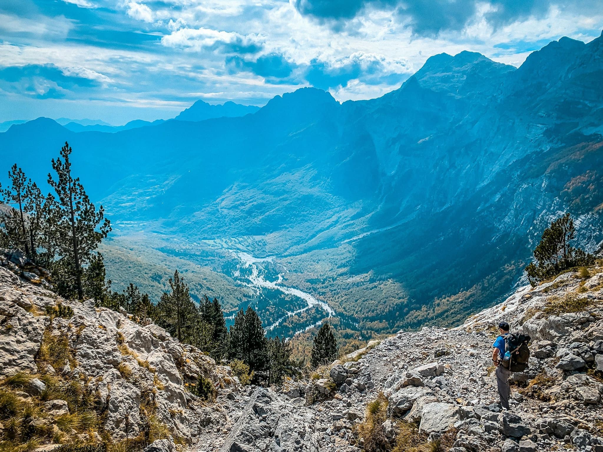 A hiker on a rocky trail above the Valbona valley