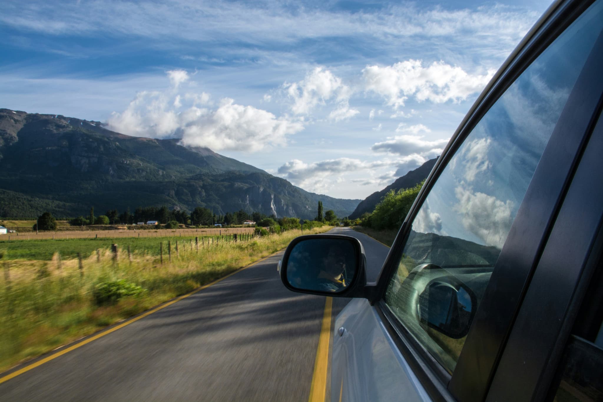 Side view of a car driving on a road near the mountains in Slovenia